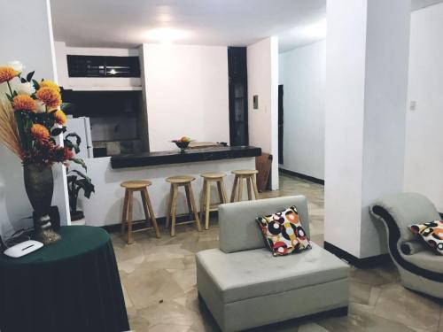a living room with a chair and a kitchen at Departamentos 3 hab Manta - centro in Manta