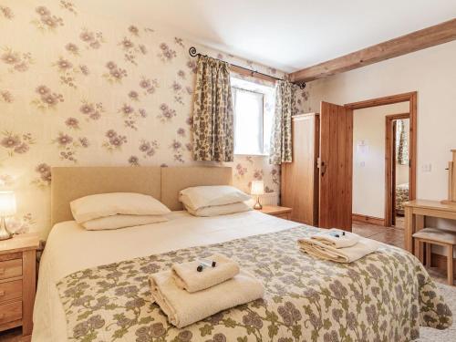 a bedroom with a bed with towels on it at Punch Cottage in Little Glenham