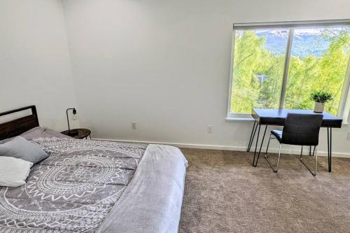 a bedroom with a bed and a table and a window at Modern 4BR Loft- Denali View, Roofdeck, Pool Table in Eagle River