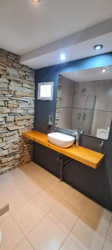a bathroom with a sink and a stone wall at Alta Patagonia Apart in Viedma