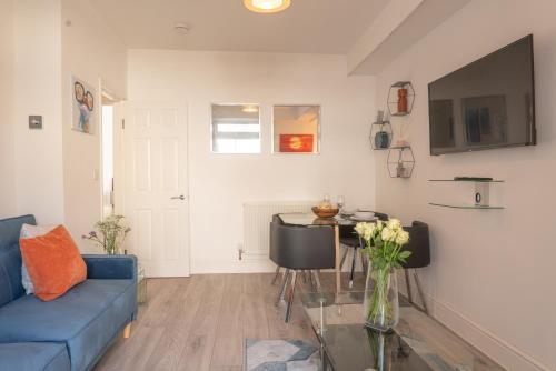 Una sala de estar con un sofá azul y una mesa. en Highfield House - 1 Bed-Sleeps 2-TJS20HH, en Ilfracombe