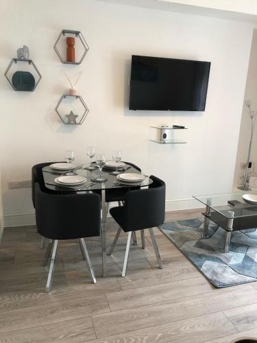 a dining room with a table and chairs and a tv at Highfield House - 1 Bed-Sleeps 2-TJS20HH in Ilfracombe