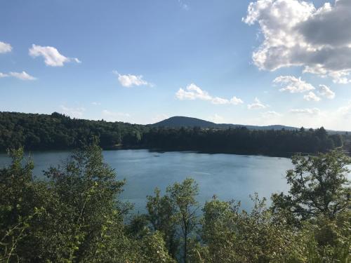 a view of a lake with trees and mountains in the background at Maison independante pour 2 tout inclus Tiny House for 2 all included in Teilhet