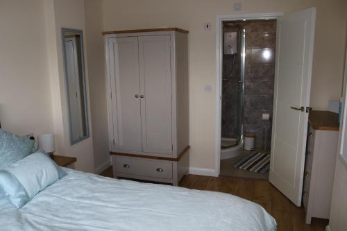 a bedroom with a bed and a bathroom with a shower at Lovely 1 bedroom basement apartment with stunning views in Bodfari