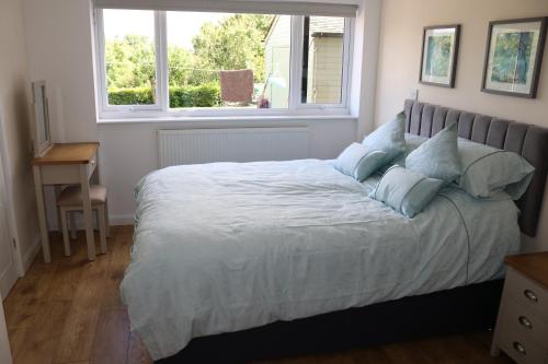 a bedroom with a large bed with a window at Lovely 1 bedroom basement apartment with stunning views in Bodfari