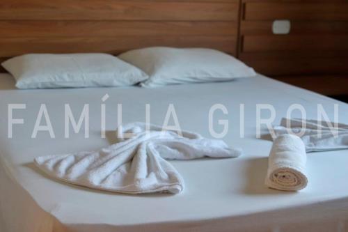 1 cama blanca con 2 toallas y 1 toalla en Flats a 100 mts da Praia, en Porto Seguro