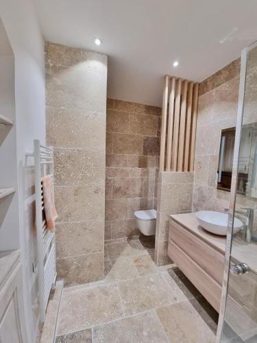 une salle de bain avec une douche, un lavabo et des toilettes dans l'établissement L'île rousse, hypercentre à 100 m de la plage, à LʼÎle-Rousse