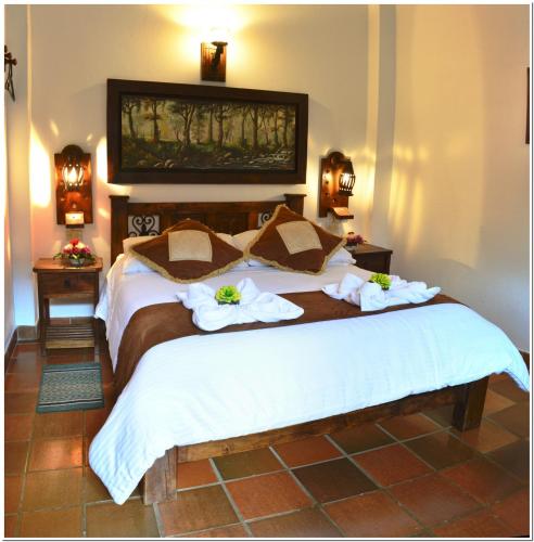 a bedroom with a large bed with towels on it at Hotel Antonio Nariño in Villa de Leyva