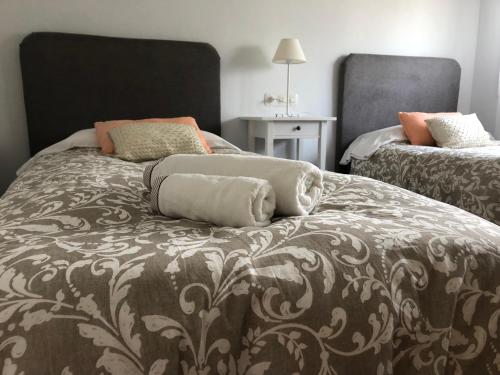 una camera con due letti con cuscini sopra di Chalet Meu Lar a O Casal Pontevedra