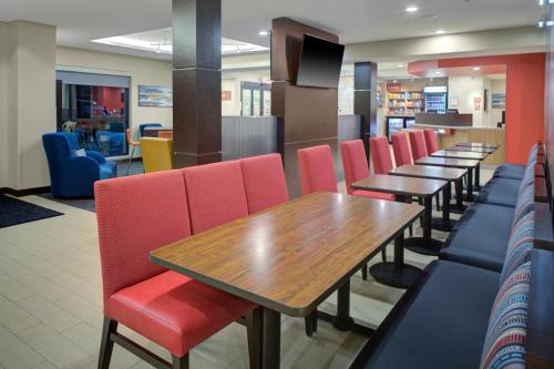 a dining room with tables and red chairs at TownePlace Suites by MarriottDetroit Canton in Canton