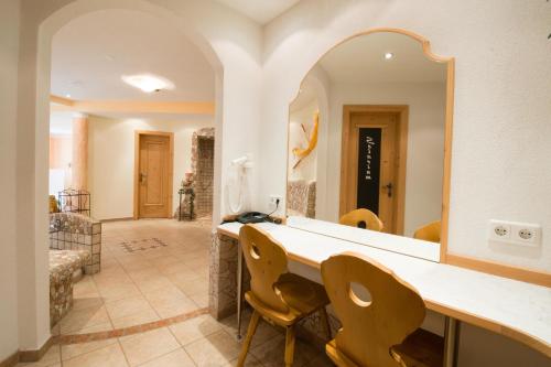 a bathroom with a vanity with chairs and a mirror at Garni Mathonerhof in Ischgl