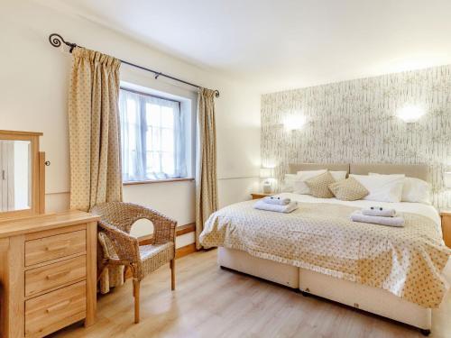 Un dormitorio con una cama y un escritorio y una ventana. en Horseshoe, en Little Glenham