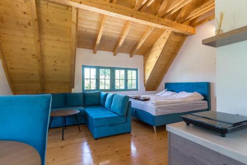 a living room with a blue couch and a bed at Retro Village Ravne in Visoko