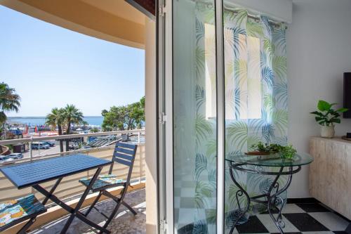 balcón con mesa y vistas al océano en Apartment T2 air-conditioned sea view, en Saint-Laurent-du-Var