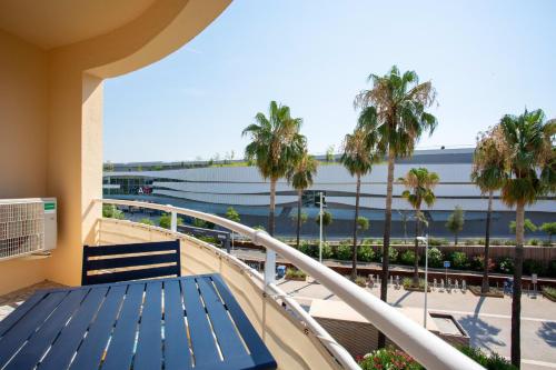 d'un balcon avec un banc bleu et des palmiers. dans l'établissement Appartement T2 climatisé vue mer, à Saint-Laurent-du-Var