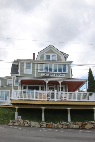 a large house with a balcony on the side of it at The Lakeview Inn & Cottages in Weirs Beach