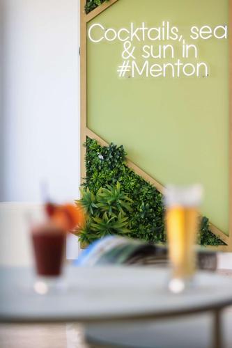 a mirror hanging on a wall with a plant at Best Western Hotel Mediterranee Menton in Menton