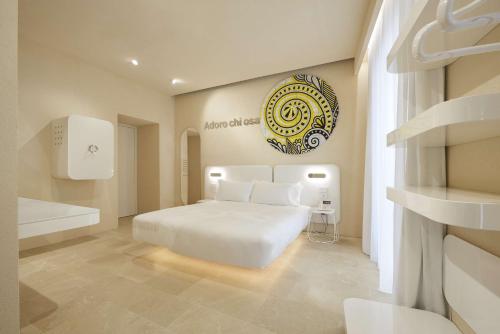 a bedroom with a white bed and a bath tub at Palazzo Gatto Art Hotel & SPA - BW Premier Collection in Trapani