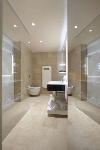 a bathroom with a sink and a bath tub at Palazzo Gatto Art Hotel & SPA - BW Premier Collection in Trapani