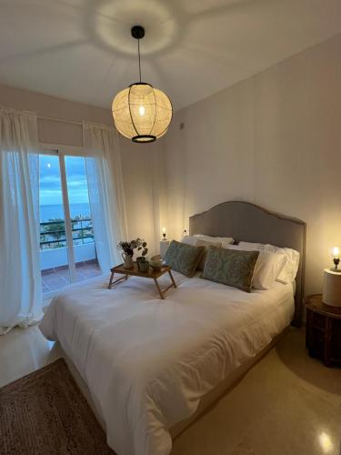 1 dormitorio con 1 cama grande y vistas al océano en Vistas al mar en Jardines del Mar Mediterráneo, en Castillo de Sabinillas