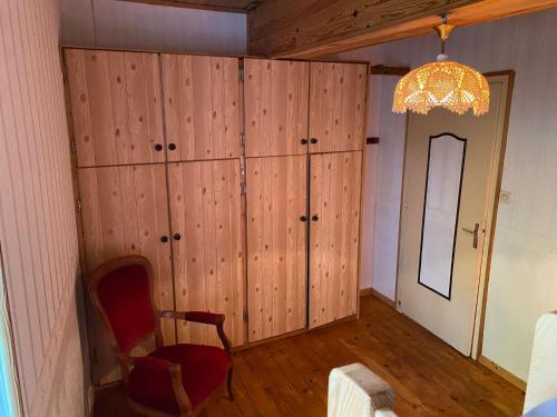 a room with wooden walls and a chair and a chandelier at Petit coin de paradis à 10 min de St-Girons in Montjoie-en-Couserans