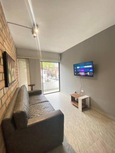 a living room with a couch and a flat screen tv at Casa tradicional - Cerca a la Zona Rosa in Envigado