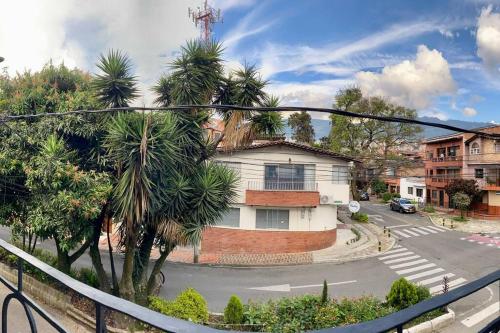 a view of a street with a house and palm trees at Casa tradicional - Cerca a la Zona Rosa in Envigado