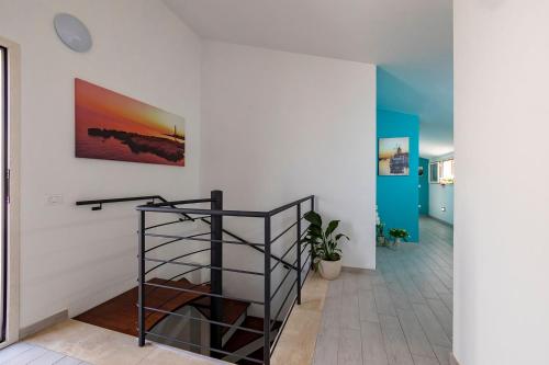 una escalera en una habitación con una pintura en la pared en Brezza Salina, en Torre Nubia