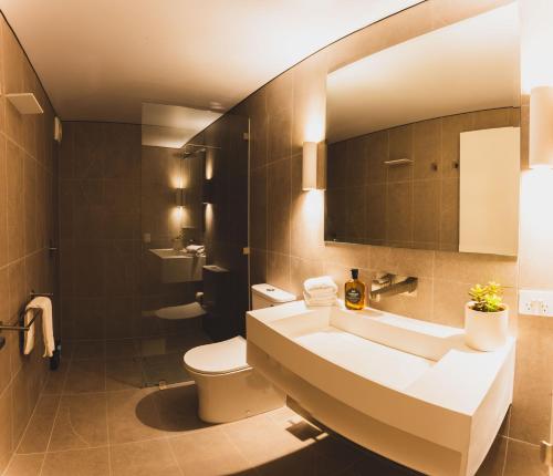 a bathroom with a sink and a toilet and a mirror at Kunama Townhouses in Jindabyne