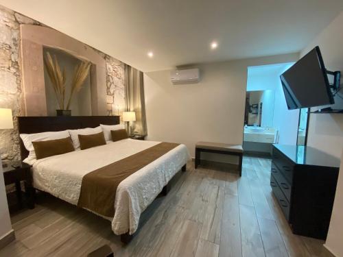 a bedroom with a bed and a flat screen tv at Hotel Casa Faroles Centro Histórico in Zacatecas