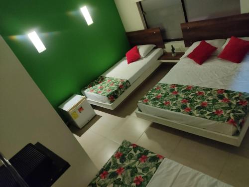 two beds in a room with green walls at Arizona Ranch Hotel in Girardot