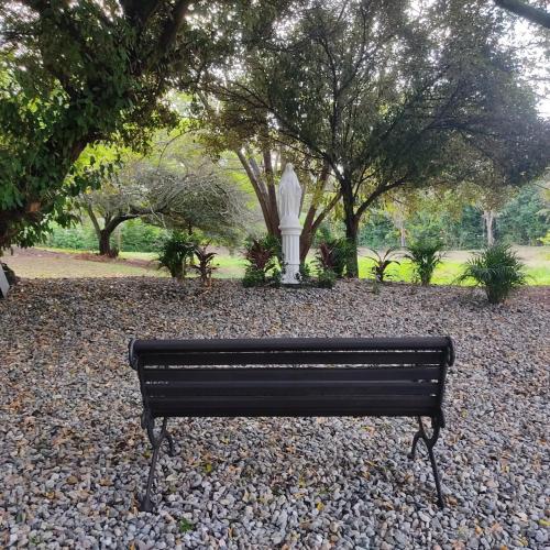 a park bench with a statue in the background at Arizona Ranch Hotel in Girardot