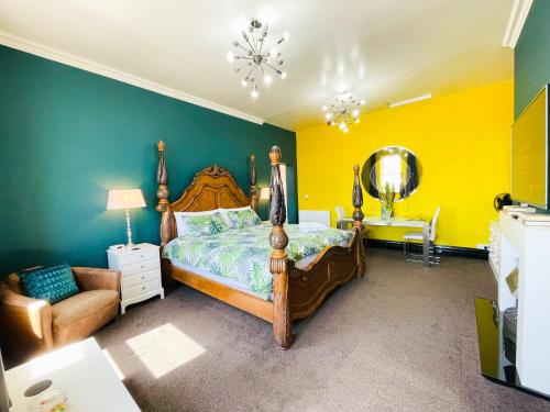 1 dormitorio con cama, silla y espejo en PHOENIX Executive Apart-Hotel en Goole