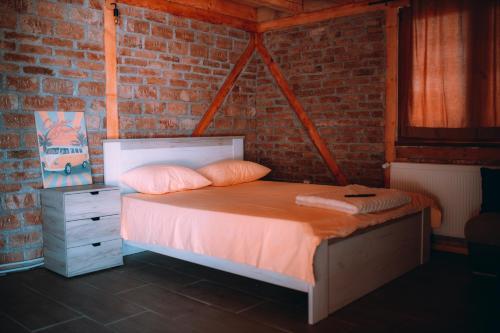 una cama en una habitación con una pared de ladrillo en Cartagena Villa & Spa, en Brčko