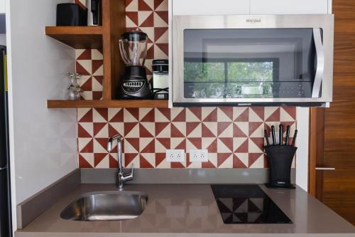 a kitchen with a sink and a microwave at Central Park ModernStudio, Gym, Spa, Wi-Fi, cowork in Tulum