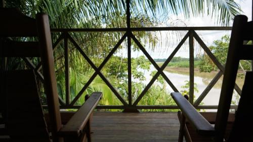 a view from the porch of a resort with two chairs at Andean Wings Sotupa Eco Lodge in Puerto Maldonado