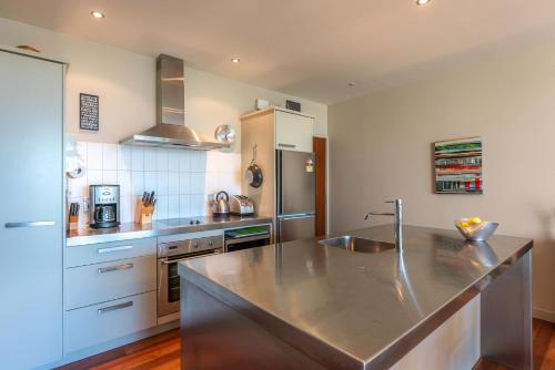 a kitchen with a sink and a counter top at The Sands Apartment 23 - Stay Waiheke in Onetangi