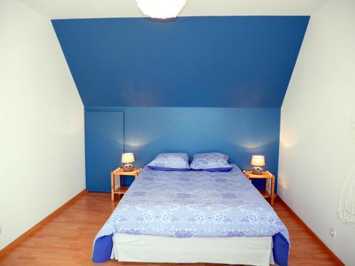 a blue bedroom with a bed and two lamps at Holiday Home in Plouneour near Sandy Beach in Brignogan-Plages