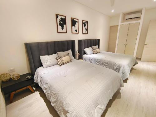 a bedroom with two beds with white sheets at 1st Luxury Warehouse in Cancún