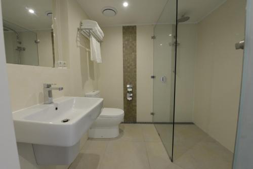ein Bad mit einem Waschbecken, einem WC und einer Dusche in der Unterkunft Cassowary Hotel in Runai