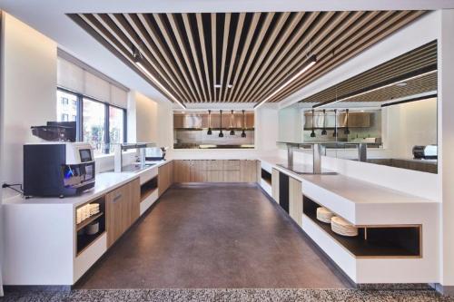eine große Küche mit weißen Arbeitsflächen und einer Kassettendecke in der Unterkunft Mary MacKillop Place in Sydney
