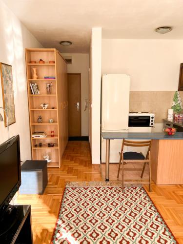 a kitchen with a counter and a table and a refrigerator at Panda Apartment in Karaburma