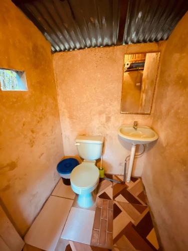 a small bathroom with a toilet and a sink at The Mudhouse Hostel Mompiche in Mompiche
