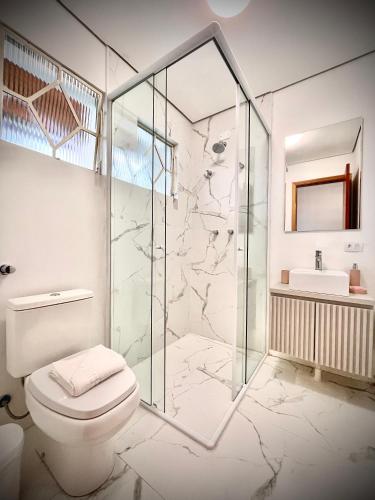 a bathroom with a glass shower and a toilet at Casa Três Rios - Campos do Jordão in Campos do Jordão