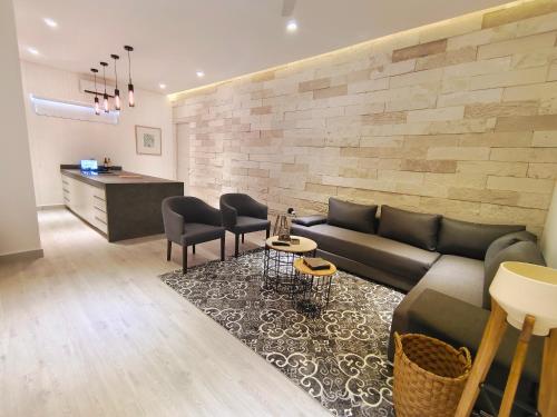 a living room with a couch and chairs and a counter at 1st Luxury Warehouse in Cancún