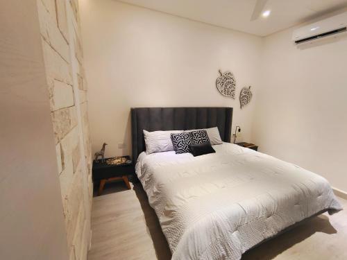 a bedroom with a bed with a black headboard at 1st Luxury Warehouse in Cancún
