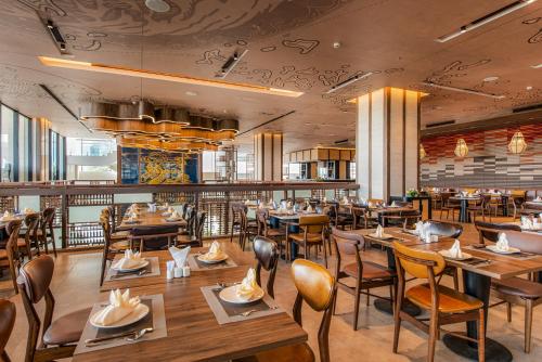 a dining room with wooden tables and chairs at Hotel Soleil Ha Long, Trademark Collection by Wyndham in Ha Long
