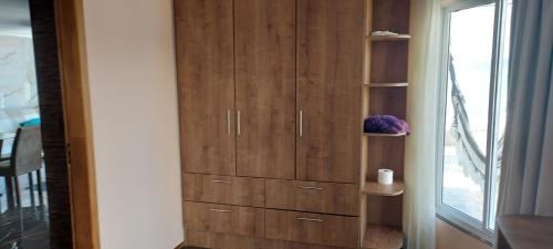 a wooden cabinet in a room with a window at Apartamento de Cobertura frente para o mar Itapema in Itapema