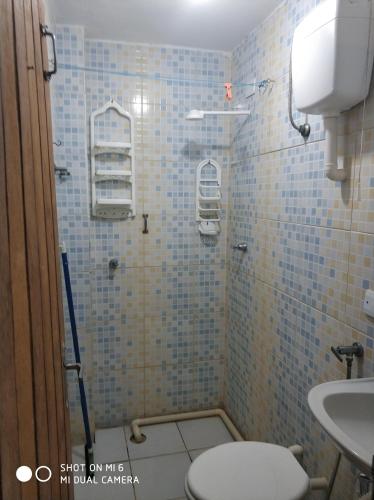 a bathroom with a shower with a toilet and a sink at Kitnet Clokel ap 104 A in Jacumã