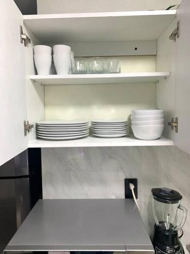 a kitchen with white plates and bowls on shelves at Private Penthouse / Penthouse Privado in Mexico City